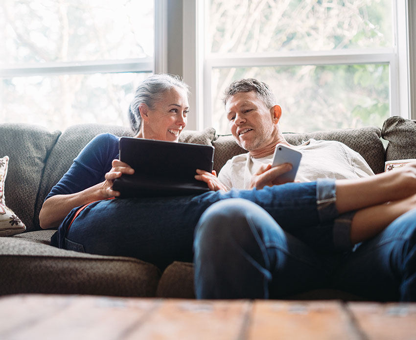 Couple on the couch with tablet and phone