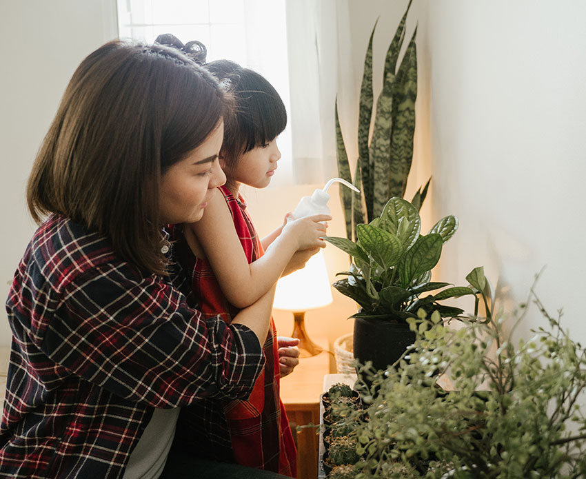 Mom and daughter watering plants
