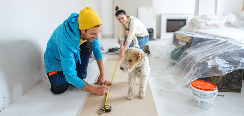 Couple doing home renovations with their dog watching