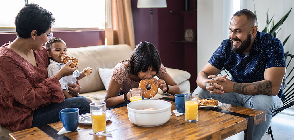 Family eating breakfast in their living room together