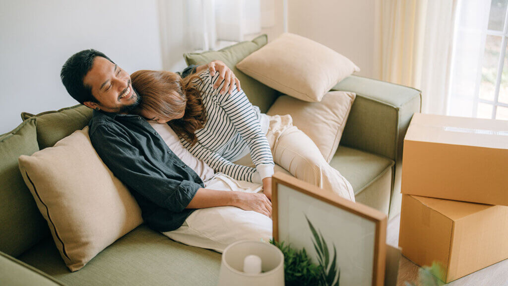 Couple hugging and resting together on a couch while moving
